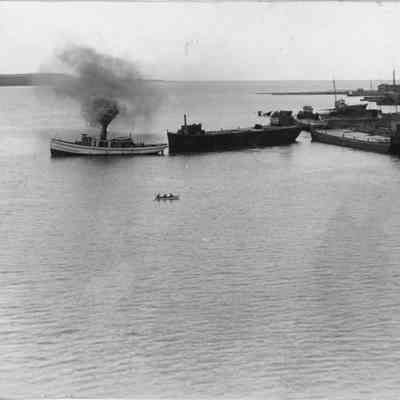 tugboat billowing smoke alongside other vessels