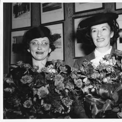 Mrs. John Butterweck and Mrs. Sydney T. Smith holding roses