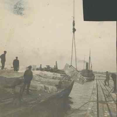 Workers loading stone onto barge
