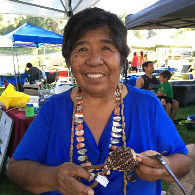 Jennifer Malone holding the rattle at the time the donor acquired it