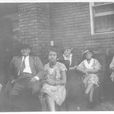Group Seated Outside Butcher Home