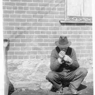 Man Crouched on Sidewalk