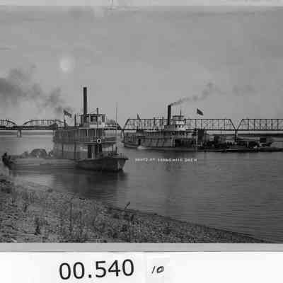 W.R. Todd and Twin Cities load at the end of a dock. Train on NPRR bridge in background