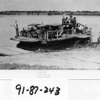 Wanista was built at Ainsworth in 1908. Move to the Pasco-Kennewick crossing in 1910. Ferry with Model T disembarking. 2 other autos still on ferry boat. The distillate for the gasoline engine had to be puchased from the hardware store in five gallon cans. Other photos of the boat are under 1986.030.073, .074, .075.