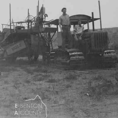 Elmer and Hazel Amon posing on tractor-drawn Holt combine at the C.C. Williams Ranch, 1932
