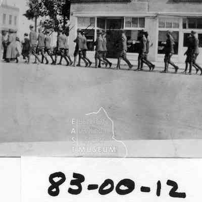 Armistice Day Parade, Looking east from the corner of Kennewick Ave. and Washingotn St. shows armed forces in marching formation with city hall/library behind.