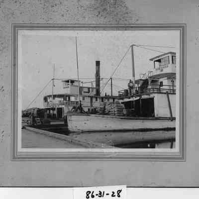Mountain Gem, Inland Empire tied up to dock. Both are loaded with sacks of grain. 4 men No ID's.