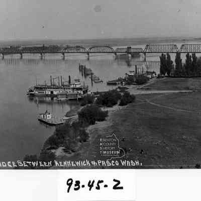 Ferry docked at Kennewick side of Columbia River. Railroad bridge also visible.
