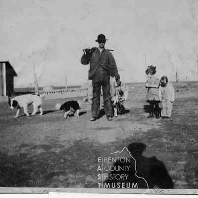 William Amon, and his two children Elmer and Evelyn, his hunting dog, game, and rifle at his ranch.
