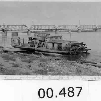 Snake River, Gas-Powered Sternwheeler Ferry. Ferry is beached at Ainsworth. NPRR bridge can be seen in background. Ferry worked traffic between Pasco and Burbank in early 20th century.