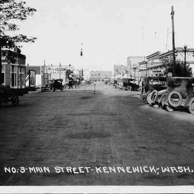 Kennewick Ave. "Main Street" with early model cars parked diagonally along street