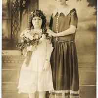Sepia-tone photo of woman & girl posed in studio with interior backdrop, Hoboken, n.d., ca. 1910-1930.