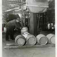 B+W photo of a cooper placing a top hoop to complete a barrel, Verdi Bros. Cooperage Co., Hoboken, March 17, 1933.