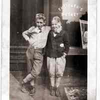 Sepia-toned photo of two young boys outside entrance to Futterer