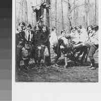 Group photo of Girl Scouts playing kickball; 2 sitting on bar between trees; no date