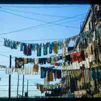 Color slide of laundry hanging from buildings.