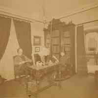 Digital image of sepia-tone photo of painter Antonio Jacobsen and wife, Mary, in their library, West Hoboken, 1889.