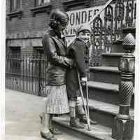 B+W photo of Paul Crone on crutch being assisted up front stairs by sister Constance, street address not known, Hoboken, March 27, 1935.