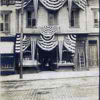 Sepia-tone photo of exterior of V. Steller store on unknown Hoboken street, decorated for grand opening, ca. 1900-1910.