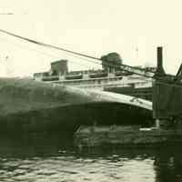 B+W photo of the bow on its side that was broken off an unidentified freight vessel in dry dock, possibly in Hoboken, no date, ca. 1940.