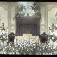 Lantern slide, color, of a synagogue interior with floral decorations, used for promotional display in Hoboken, no date, ca. 1920.