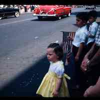 Color slide of three children watching cars at a parade.