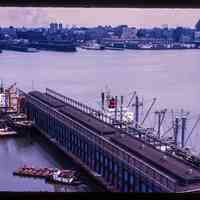 Color slide of aerial view from River and 3rd looking E at Pier B with the New York City skyline across the Hudson River