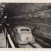 B+W photo of policeman slowing car in Holland Tunnel re-opened after truck explosion, May 15, 1949.