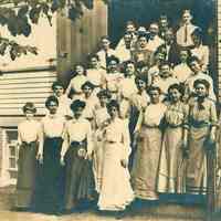Sepia-tone group photo of men & woman posed on outside steps, no place (Hoboken?), 1902.