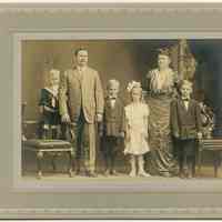 Sepia-tone photo portrait of family posed in photographer