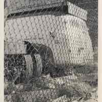 B+W photo of trash near fence belonging to Diamond Reo of Hudson County, 8th & Madison Sts., Hoboken, no date, ca. 1970-1980.