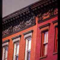 Color slide of detail view of cornices, brackets, friezes and window heads on two buildings on the E side of Willow between 12th and 13th