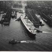 B+W aerial photo of S.S. New Amsterdam departing Holland America Lines Fifth St. Pier, Hoboken, n.d., ca. 1952-1953.