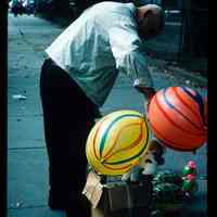 Color slide of a man with balloons and toys.