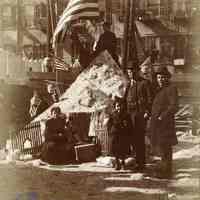 Sepia-tone photo of snow fort with 3 children in backyard, American flags, Hoboken?, n.d., ca. 1912-1918.