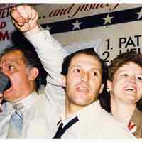 Color photo of mayoral candidate Tom Vezzetti with supporters in front of his campaign headquarters on election night, Hoboken, [June 11, 1985].