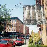 Color photo of hanging banner sign and store window for Michael Escobar, 303 Third St., Hoboken, Sept., 1-5, 2001.