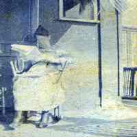 Digital image of photo of a woman seated in porch rocking chair reading a newspaper, no place (probably not Hoboken),no date, circa late 1910-1920.