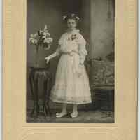 B+W photo of Rose Beck, age 13, in her confirmation dress, posed in photographer