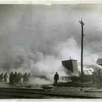 B+W photo of injured fireman being carried away during fire at piers, 15, 15 & 16 on the Hudson River, Hoboken, March 24, 1930.