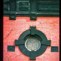 Color slide of close-up view of oculi window, decorative tile and cornice at 1100 Bloomfield on the NW corner with 11th