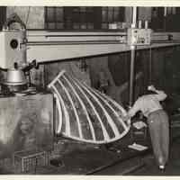 B+W photo of a man calibrating a machine with propeller blade inside Ferguson Propeller Works, Hoboken, no date, ca.1975-1980.