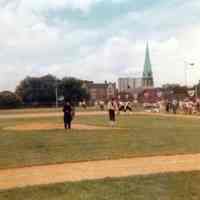 Color photo of several players and an umpire in period costume on the field at Baseball Day Ceremonies, 1976.