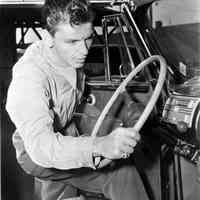 Black-and-white photo of a young Frank Sinatra getting into a car, no place, no date, ca. 1945.