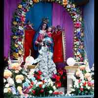 Color slide of a statue of a Madonna with flowers.