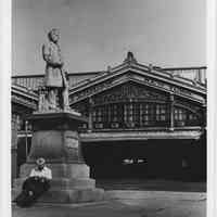 B+W photo of Sam Sloan Statue with ferry section of Lackawanna Terminal in background, Hoboken, n.d., ca. early 1970s.