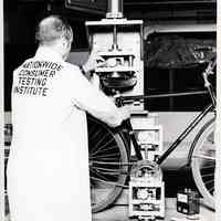 B+W photo of bicycle load test as per B.M.A. 6 at United States Testing Co. facility, Hoboken, N.d., ca. 1979-1990.