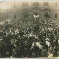 B+W photo of the Madonna at the entrance with a large assembly of people on the street.at St. Ann