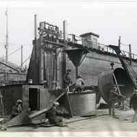 B+W photo of men working on deck gun mounts for a merchantman ship at Todd Shipyards, Hoboken, Nov. 26, 1941.