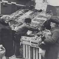 Reference image of printed photo image of a produce truck vendor with customers from pg 34 of archives catalog 2002.026.0002, Hoboken, ca. 1975.